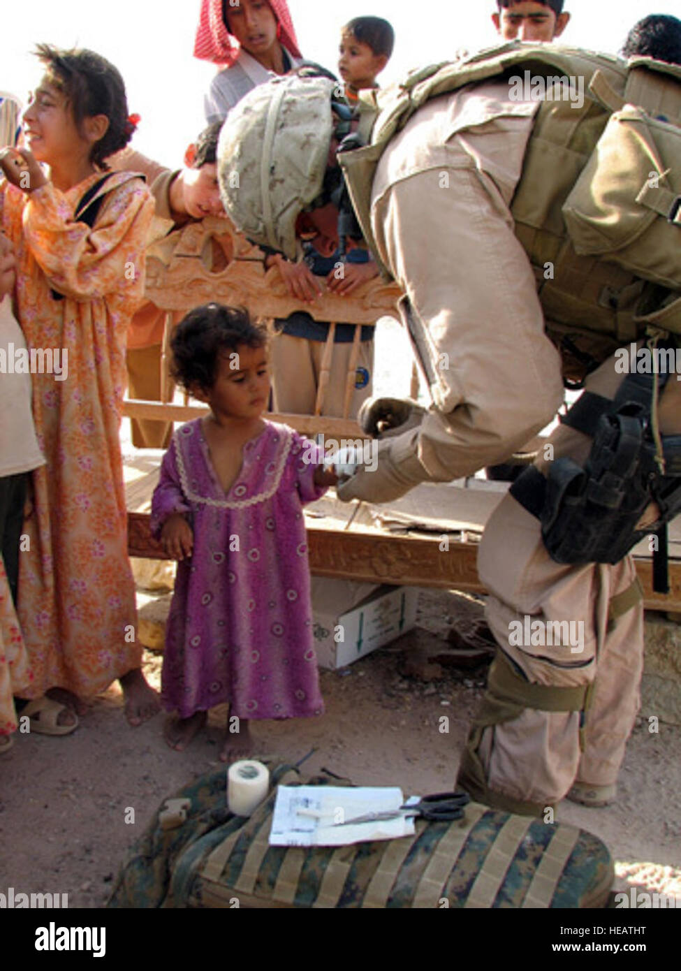 FALLUJAH, Iraq (Aug. 29, 2007) - U.S. Navy Hospital Corpsman Andrew Piazza applies a dressing to the hand of an Iraqi child discovered with second degree burns during a humanitarian assistance mission on Aug. 29, 2007. Piazza is assigned to Camp Fallujah, Iraq, and participated in a Civil Affairs mission conducted by Special Operations Task Force-West and a U.S. Marines Expeditionary Force Headquarters Battalion to deliver school supplies and clothing items to local children. Nearly 200 backpacks and more than 500 clothing items were distributed to approximately 200 children during the mission Stock Photo