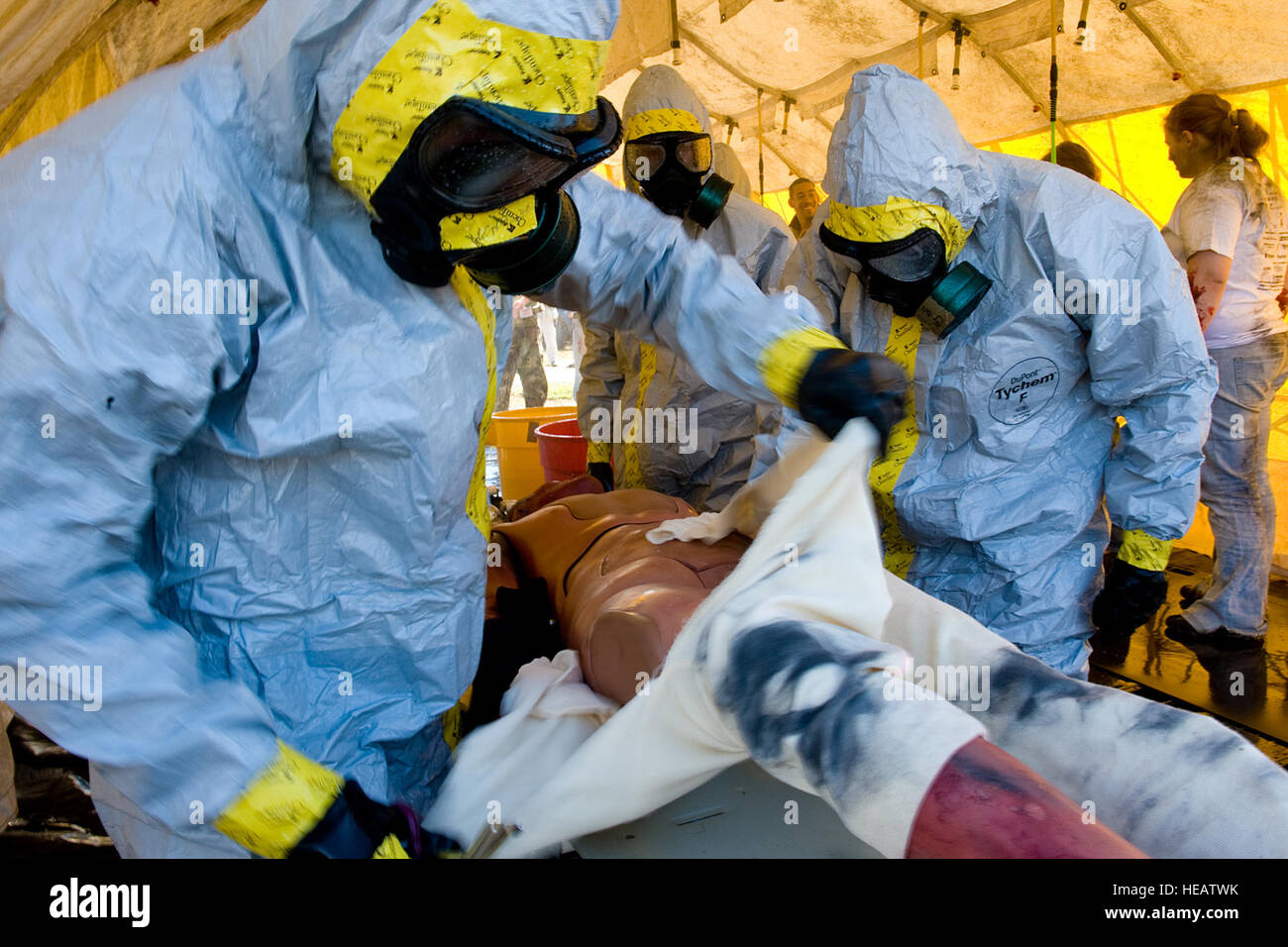 A Army hazardous material decontamination operator removes the clothing