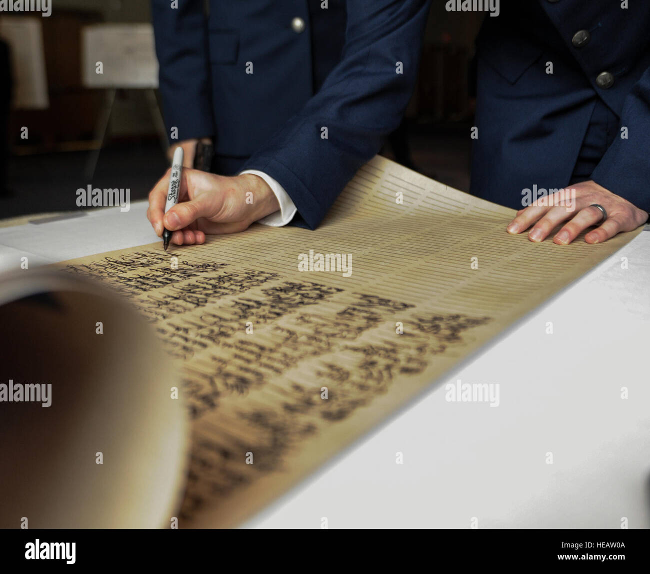 A U.S. Air Force airman signs a scroll during an Order of the Sword
