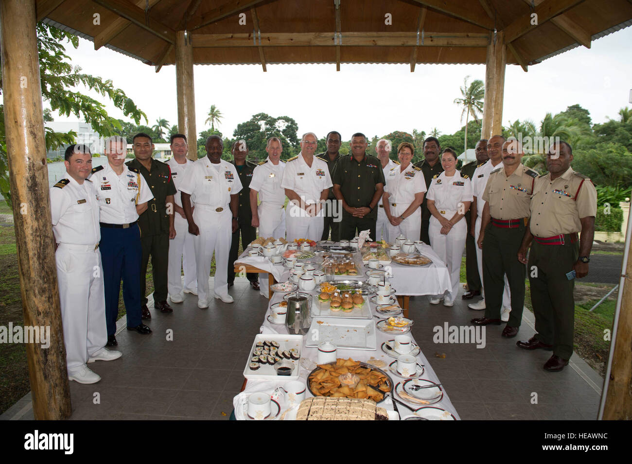 Military leaders from the Republic of Fiji Military Forces, U.S. Navy and Army, and the Royal Australian Navy meet for morning tea at the Republic of Fiji Military Forces Strategic Headquarters during Pacific Partnership 2015. The event was hosted by Brig. Gen. Mosese Tikoitoga (center right), commander of the Republic of Fiji Military Forces. The hospital ship USNS Mercy (T-AH 19) is in Suva, Fiji, for its first mission port of PP15. Pacific Partnership is in its tenth iteration and is the largest annual multilateral humanitarian assistance and disaster relief preparedness mission conducted i Stock Photo