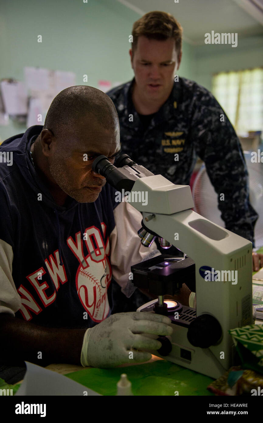 ARAWA, Autonomous Region of Bougainville, Papua New Guinea (July 3, 2015) Thomas Matanie, an Arawa Medical Center lab technician and Cmdr. Drake Tilley, an infectious disease doctor from Myrtle Beach, S.C., test a microscope during a community health engagement at the Arawa Medical Clinic as part of Pacific Partnership 2015. Medical personnel from the hospital ship USNS Mercy (T-AH 19) were at the clinic to provide residents with medical services and information to raise health awareness. Mercy is currently in Papua New Guinea for its second mission port of PP15. Pacific Partnership is in its  Stock Photo