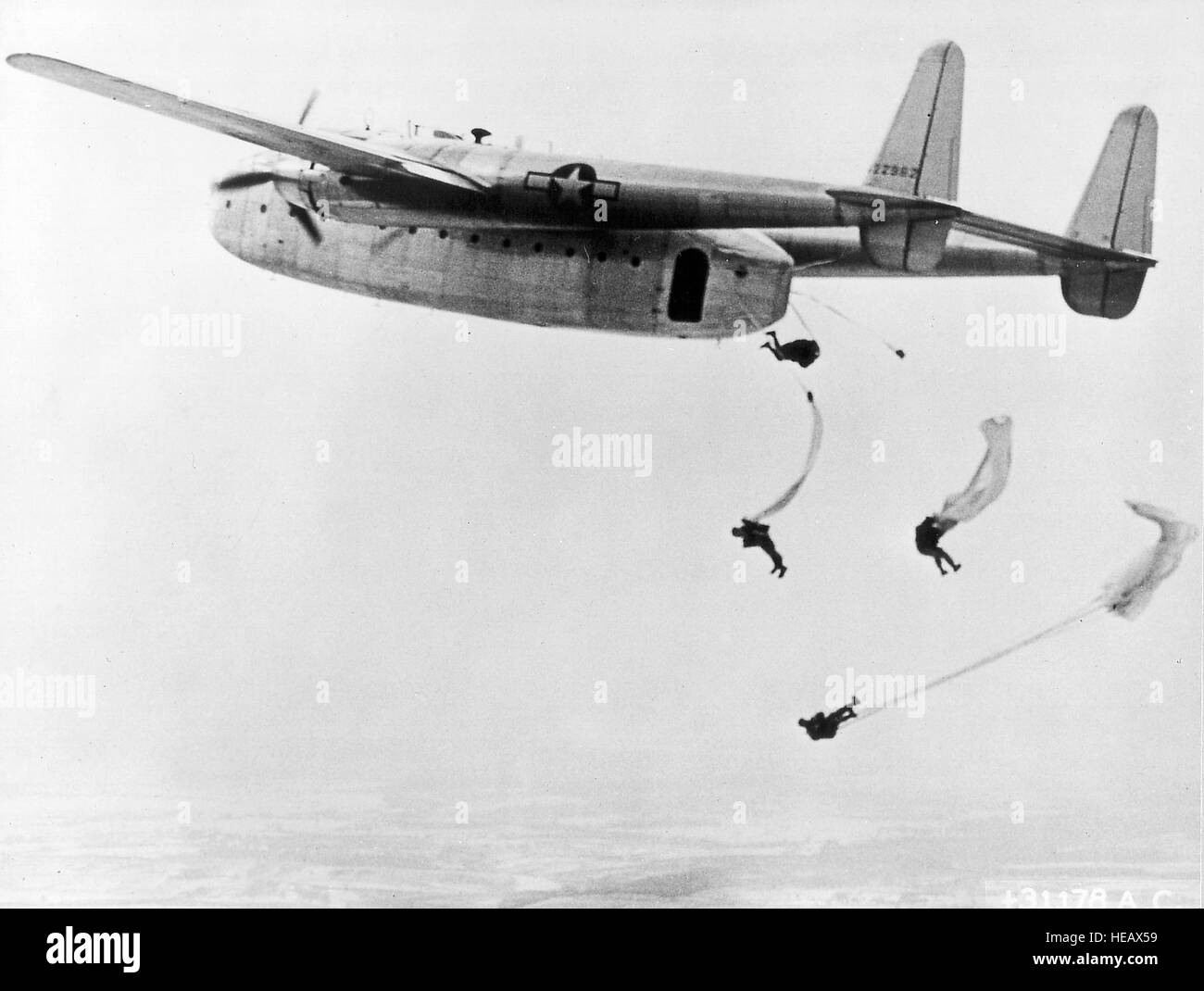 Paratroopers jumping from a Fairchild C-82 'Packet'.  It was primarily used for cargo and troop transport, but it also            was used for paratroop operations and towing gliders. Its capacity was 41 paratroops or 34 stretchers and it had clam-shell rear doors that allowed easy entry of trucks, tanks, artillery, and other bulky cargo. Stock Photo