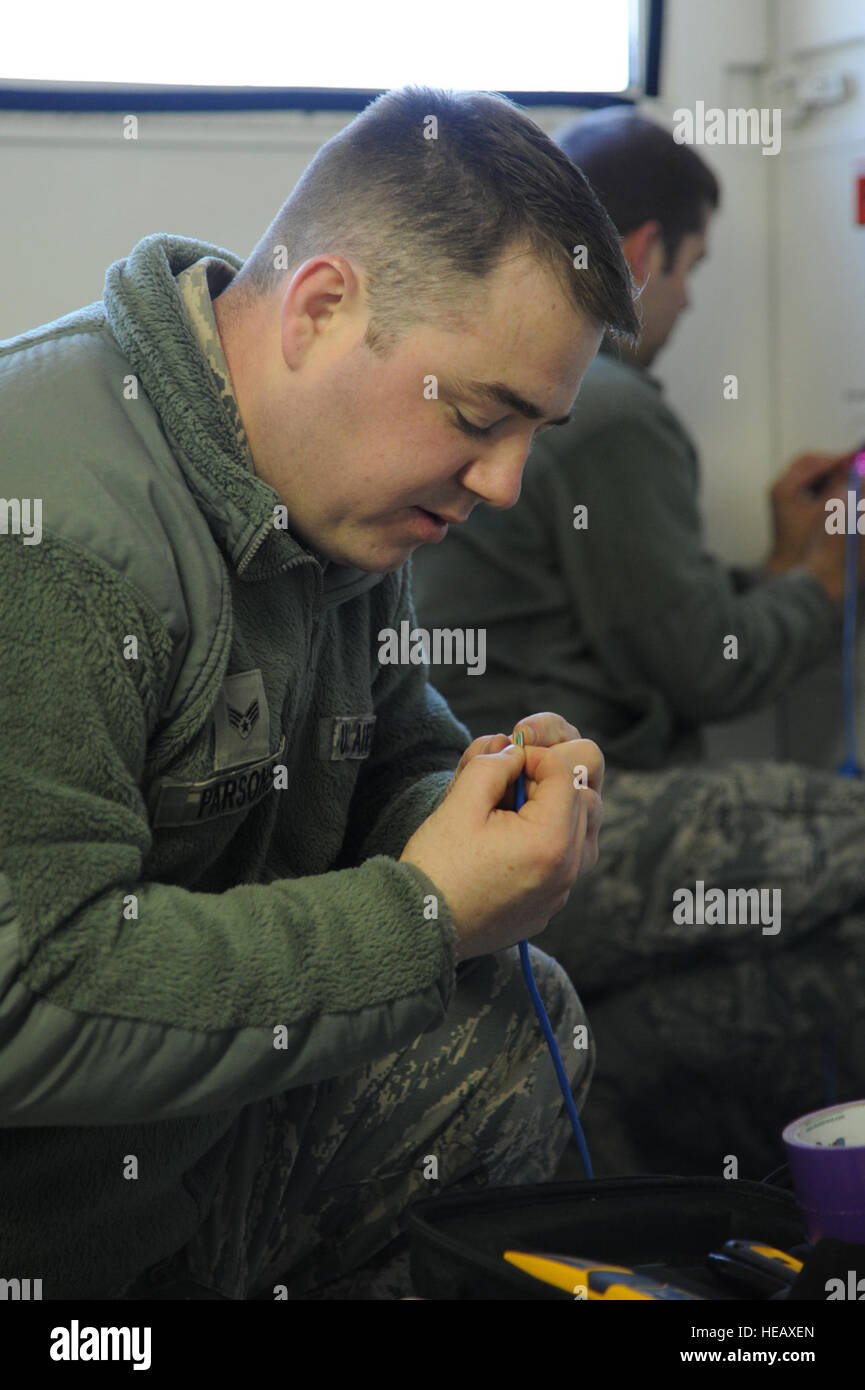 U.S. Air Force Senior Airmen Harry Parsons from the 239th Combat Communications Squadron, Jefferson Barracks, St. Louis, MO., twists wires to install a RJ-45 connector for a voice over internet protocol phone May 6, 2014 during exercise Patriot Warrior,  Fort McCoy, Wis. United States military reserve components from all branches participate in combined exercises Patriot Warrior, Global Medic, Diamond Saber and CSTX in preparation for upcoming deployments in joint environments.  Master Sgt. Francisco V. Govea II/ Released) Stock Photo