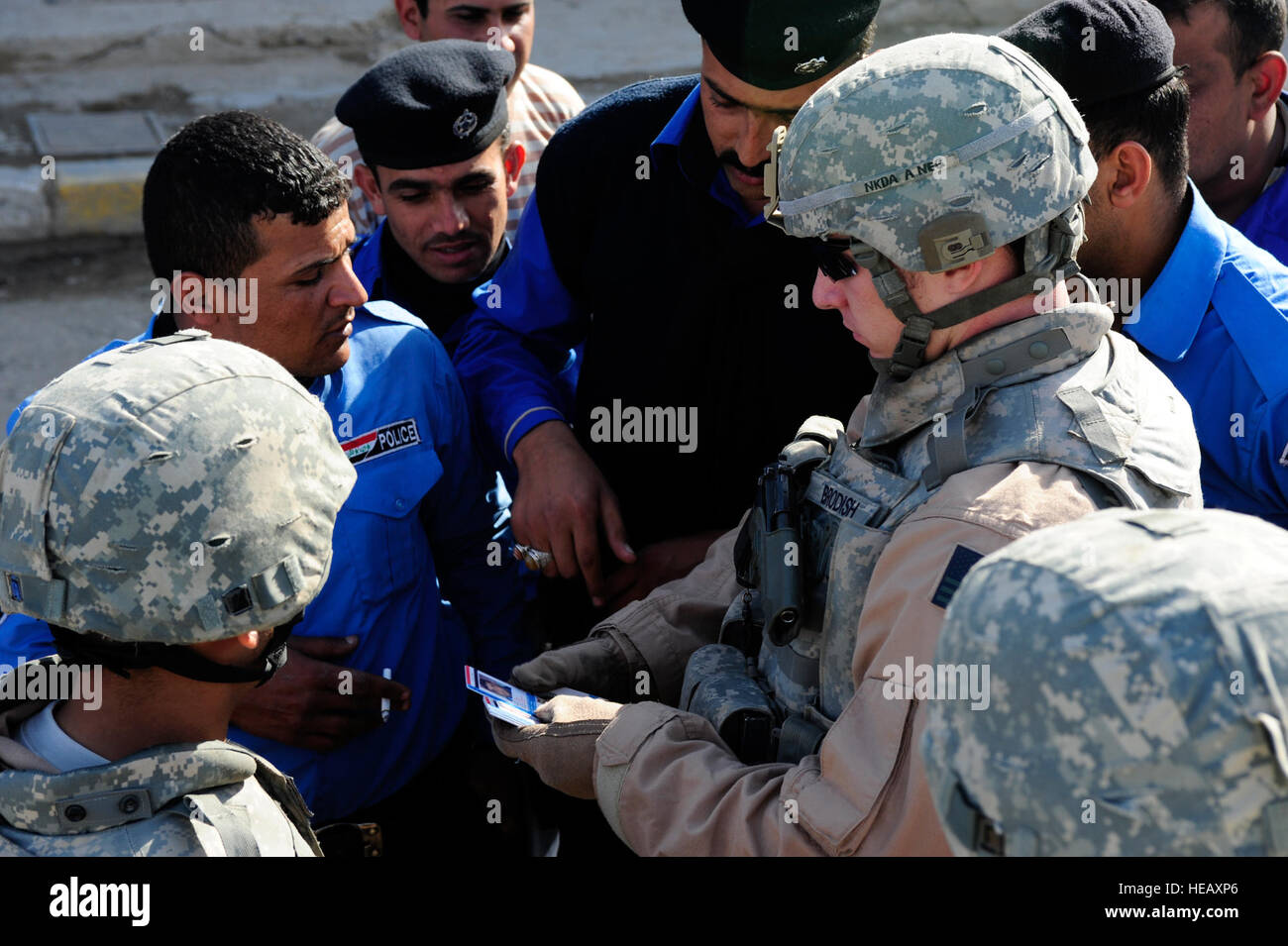 U.S. Air Force Senior Airman George Brodish, of the 732nd Expeditionary Security Forces Squadron, Detachment 3, speaks with an Iraq police captain to identify badges for his men, in Rashid, Iraq, on Feb. 13. Stock Photo