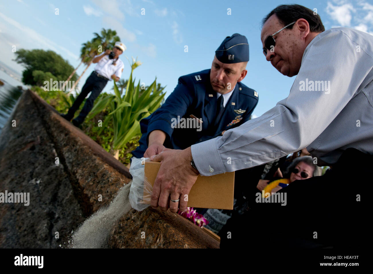 Bill Perry, son of retired Senior Master Sgt. Raymond Perry, is assisted by Capt. Andrew Stewart, 15th Wing commander’s action group, to spread the ashes of his late father during a ceremony Dec. 7, 2012 at Joint Base Pearl Harbor-Hickam, Hawaii. Perry was a Dec. 7, 1941, Hickam Field attack survivor whose wishes were for his family to return him to Hickam and spread his ashes. He served 26 years in the Air Force and was a founding member of the pararescue career field. Staff Sgt. Mike Meares) Stock Photo