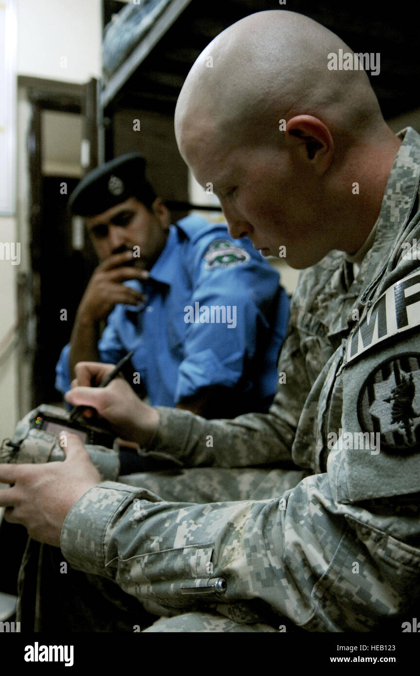 U.S. Army Spc. John Davis, a military policeman from 411th Military Police Company, 716th Military Police Battalion, 101st Airborne Division, enters information about an Iraqi police officer into a handheld interagency identity detection equipment device at a Joint Security Station in the Meshahdah province of Iraq, on April 8, 2008. Tech. Sgt. William Greer) Stock Photo