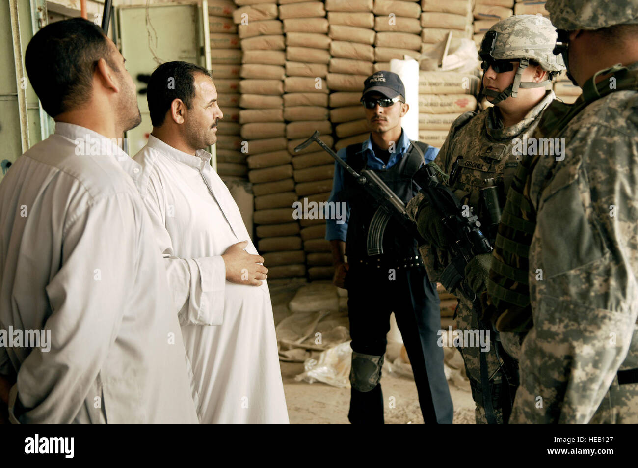 U.S. Army Staff Sgt. Christopher Gronli, a military policeman from 411th Military Police Company, 716th Military Police Battalion, 101st Airborne Division, and Iraqi police, talk to local shop owners to address any concerns they may have in the Meshahdah province, Iraq, during a dismounted patrol on April 8, 2008. Tech. Sgt. William Greer) Stock Photo