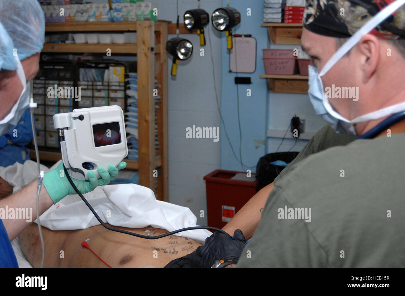 U.S. Navy Lt. Cmdr Dante Villecco, a registered nurse anaesthetist with the Forward Surgical Team (FST) assigned to Forward Operating Base (FOB) Farah, Afghanistan, utilizes a Glidescope to intubate an international contractor who sustained numerous leg fractures during an insurgent mine explosion, Jan. 24, 2010.  The FST and the Farah Provincial Reconstruction Team (PRT) medical staff routinely provide life or limb saving procedures to a variety of patients, including injured local nationals and contractors who are wounded by insurgent attacks. Stock Photo