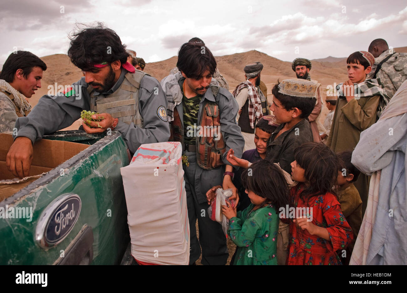 Members of the Afghan National Police pass out shoes to local children as part humanitarian assistance operations near Forward Operating Base Lane, Zabul Province, Aug. 6. Stock Photo