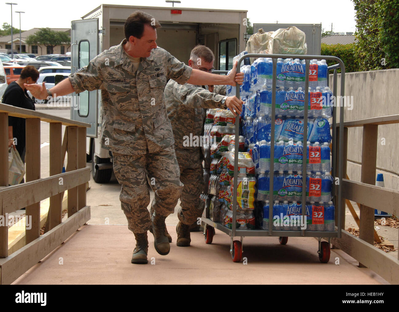 Tech. Sgt. Paul Parrinello helps fellow airmen pull a cart full of water up a ramp June 28, 2011, at Wilford Hall Medical Center Lackland Air Force Base, Texas. Parrinello was one of many volunteers to help load and unload donated goods from the American Red Cross, USO, Wounded Warriors, Pennies from Heaven, Evil Genius Racing, Blue Star Mom of San Antonio, RN Carolina Melfar of Sacramento, Calif., and WHMC Volunteer Services in support of the new CASF unit. Parrinello is from the 514th Aero Medical Staging Squadron as a Medical Technician. Stock Photo