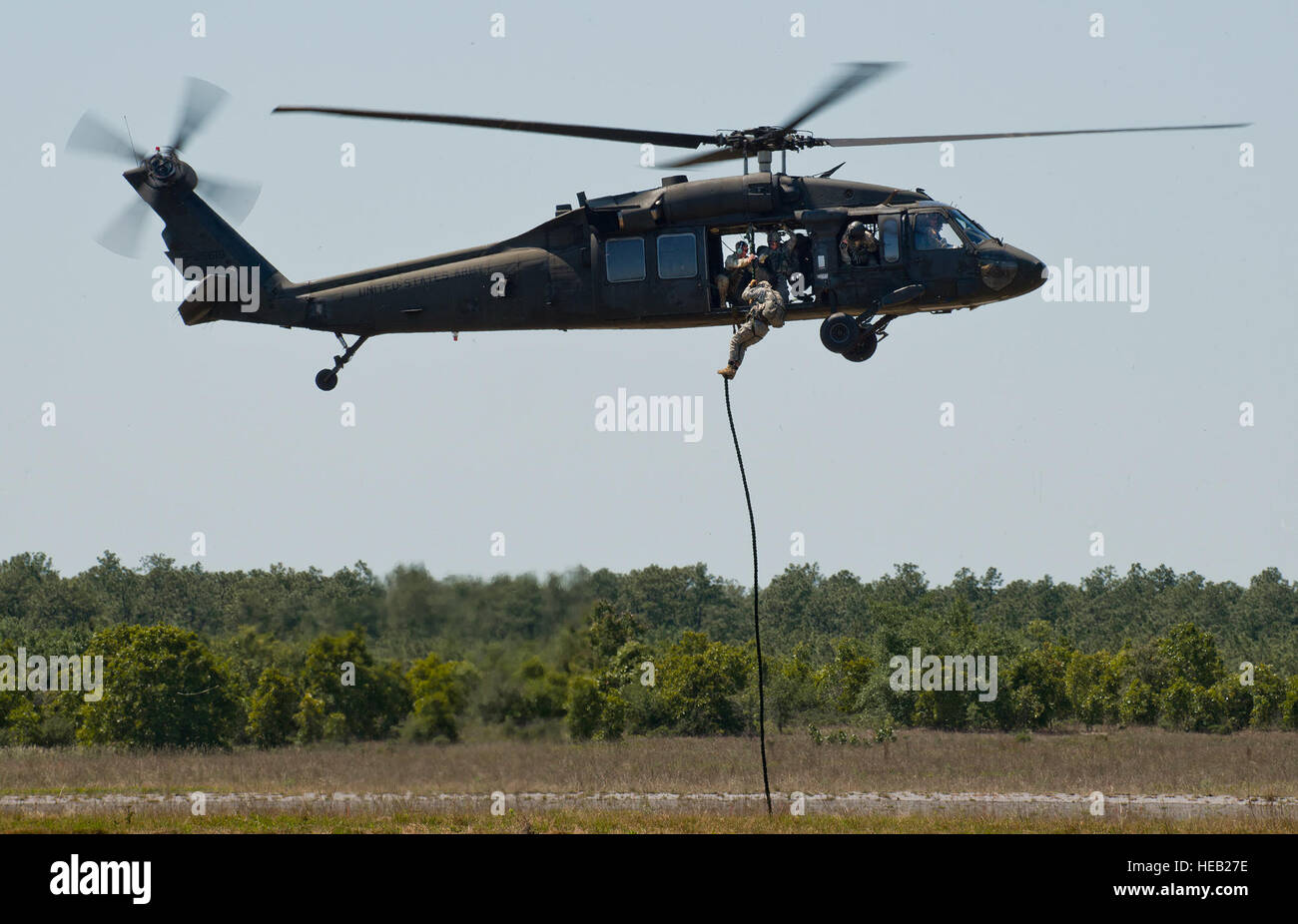 A Soldier exits a Blackhawk helicopter via a rope during a ...
