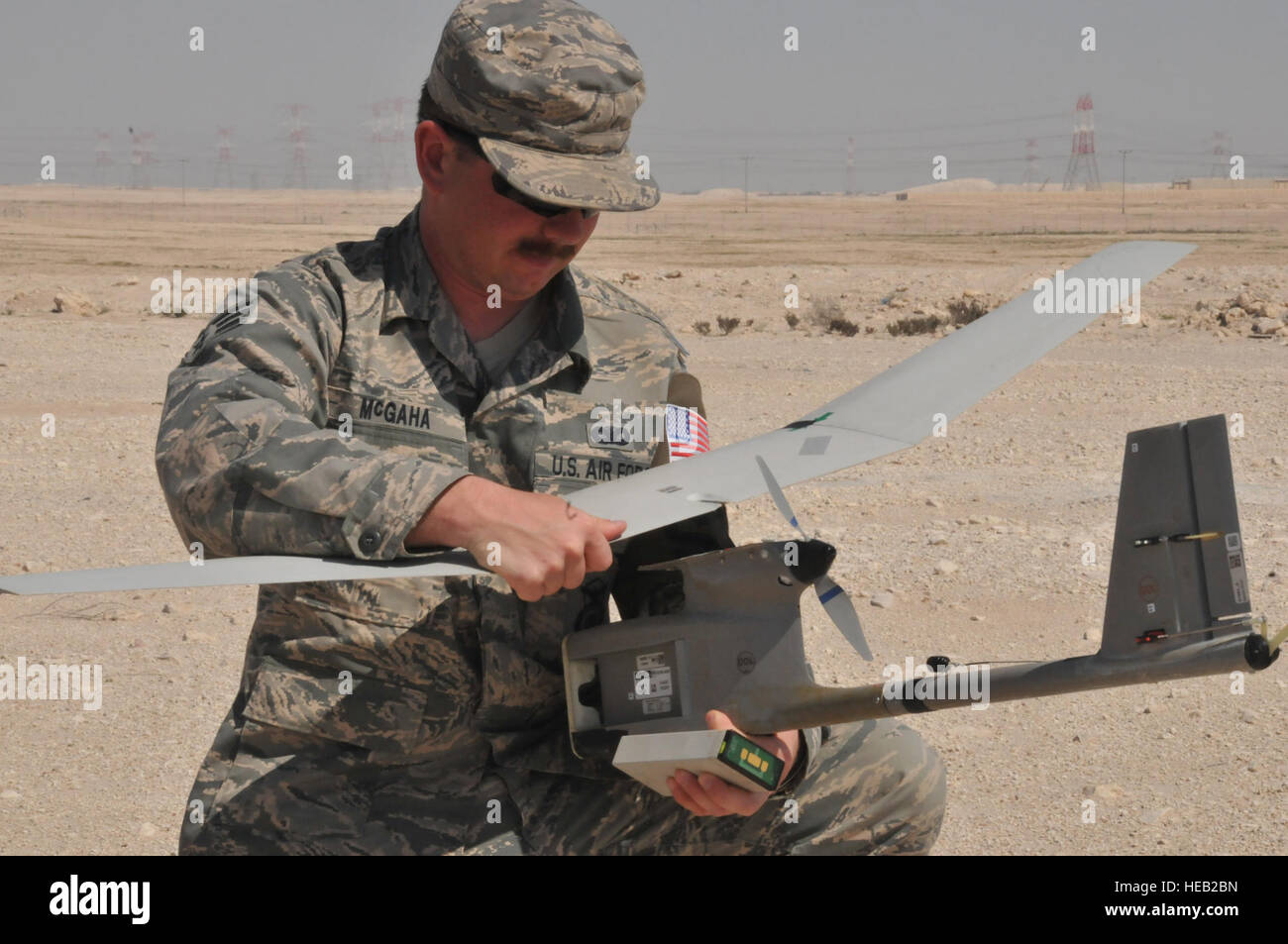 Senior Airman James McGaha, 379th Expeditionary Security Force Squadron patrolman, recovers parts of the Raven B Digital Data Link drone, after one of its flight missions Feb. 19 at Al Udeid Air Base, Qatar. After completing its flight, the Raven’s wings detached after landing which can occur and is easy to fix.  Tech. Sgt. Terrica Y. Jones Stock Photo