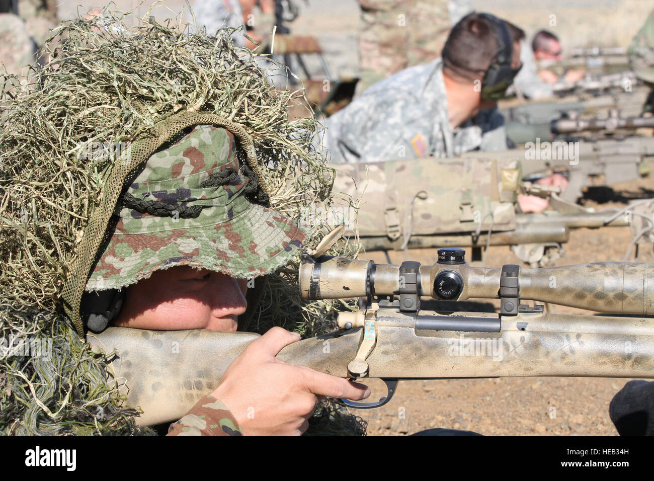 A U.S. paratrooper scans for targets behind a Barrett .50-caliber sniper  rifle while on a
