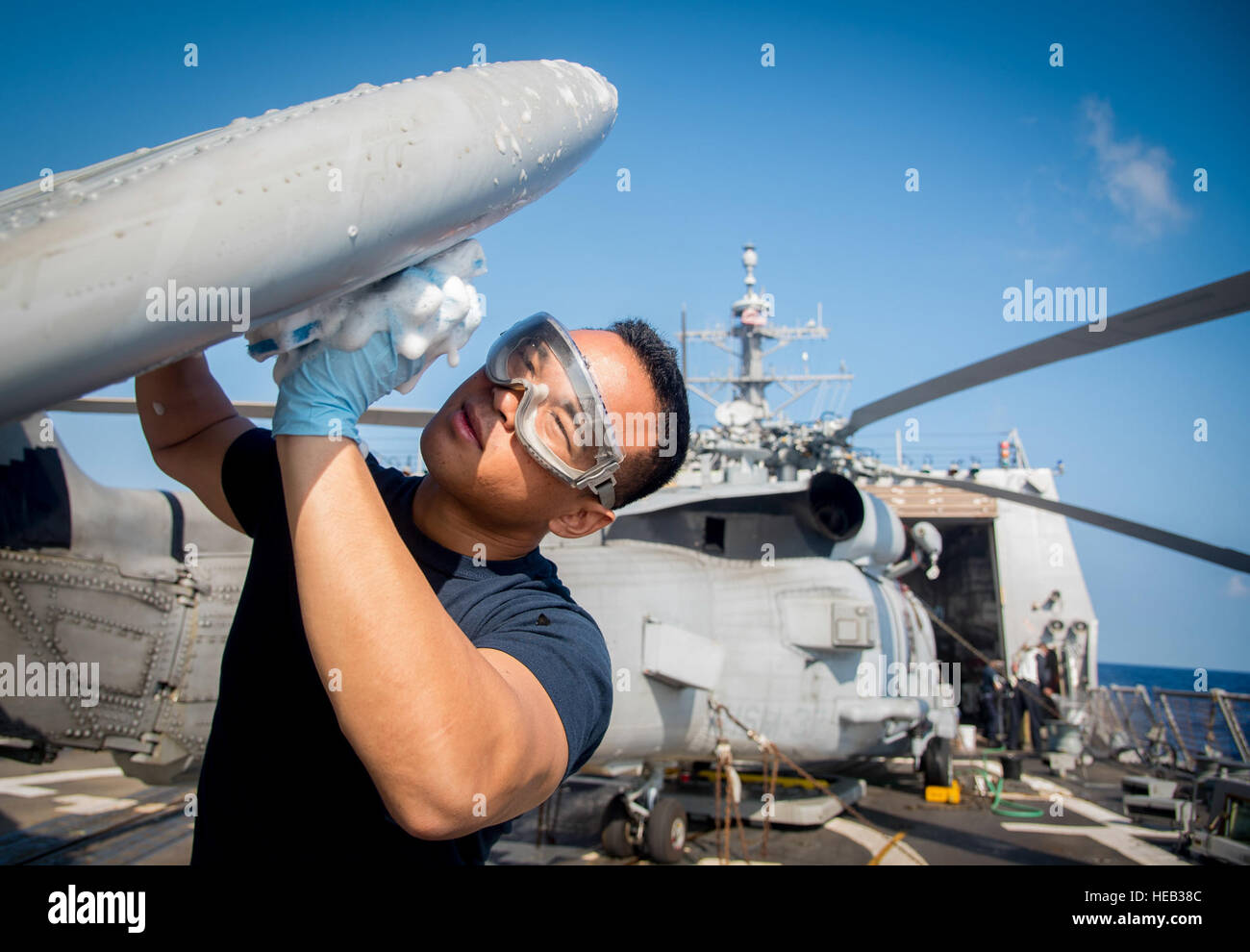 160201-N-MJ645-095   PACIFIC OCEAN (Feb. 01, 2016) Personnel Specialist 1st Class Renz E. Bismonte washes an MH-60R Sea Hawk helicopter of the Easy Riders of Helicopter Maritime Squadron (HSM) 37 aboard the guided-missile destroyer USS Chung-Hoon (DDG 93). Providing a combat-ready force to protect collective maritime interests, Chung-Hoon, assigned to the Stennis strike group, is operating as part of the Great Green Fleet on a regularly scheduled Western Pacific deployment.  Mass Communication Specialist 2nd Class Marcus L. Stanley Stock Photo