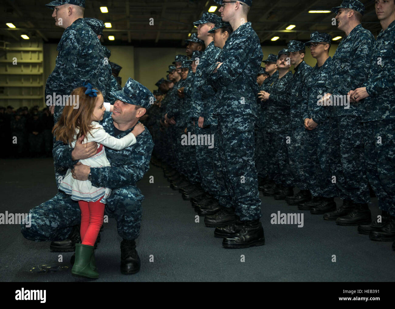 151209-N-BR087-012 BREMERTON, Wash. (Dec. 9, 2015) - Machinist's Mate 1st Class John Rasmussen, from Sacramento, Calif., hugs his daughter Lillian during a frocking ceremony in USS John C. Stennis' (CVN 74) hangar bay. Stennis' crew is currently in port training for future deployments.  Mass Communication Specialist Seaman Apprentice Cole C. Pielop Stock Photo