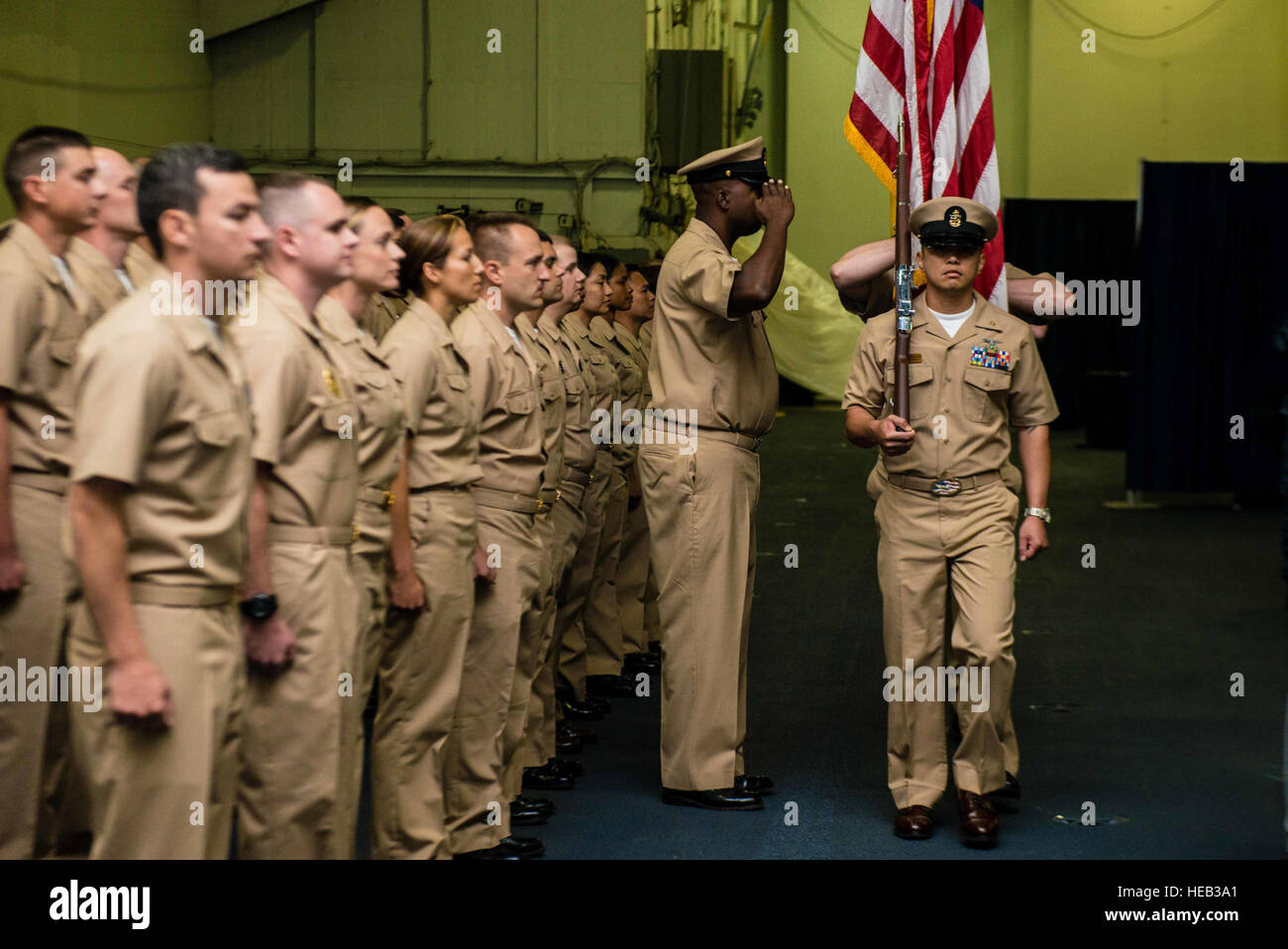 The color guard parades flags in USS John C. Stennis' hangar bay during ...