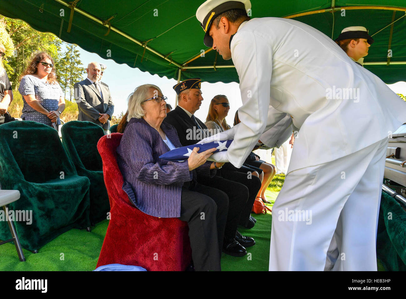 160829-N-EC099-175 BREMERTON, Wash. (Aug. 29, 2016) – Lt. Alfredo Lozano, assigned to Naval Base Kitsap, presents a folded Ensign to Ann Jordan-Remers, daughter of World War II veteran Lt. Julian Jordan. Jordan was 37 years old when the attack on Pearl Harbor took place and he was indentified with the use of DNA profiling after his body was exhumed from the Nevada-class battleship USS Oklahoma (BB 37). The funeral took place at the Lewis Funeral Chapel in Bremerton, Washington, 75 years after the attack.  Mass Communication Specialist 3rd Class Charles D. Gaddis IV Stock Photo