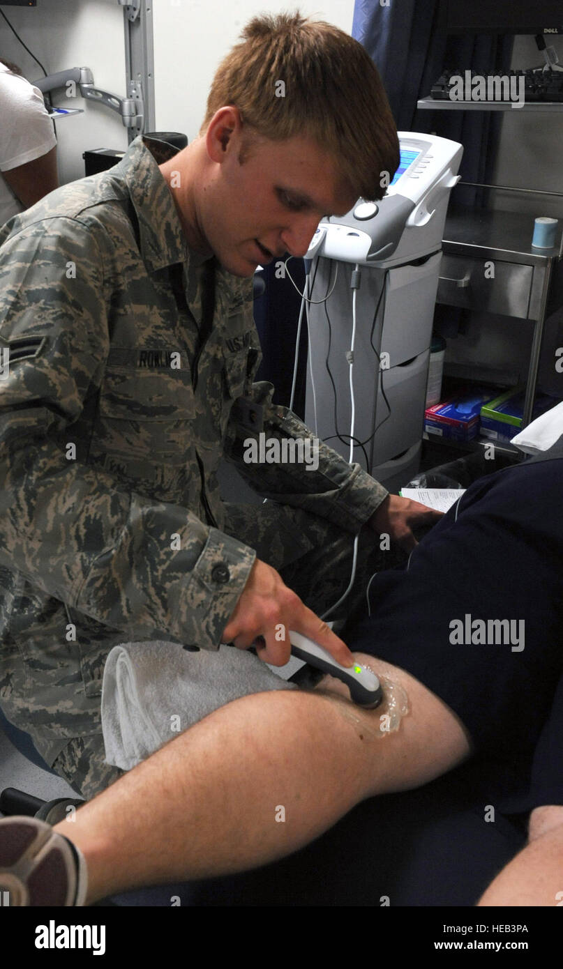 U.S. Air Force Airman 1st Class Cameron Rowland, 355th Medical Operations Squadron, uses an ultrasound machine on a patient at the physical therapy clinic at Davis-Monthan Air Force Base, Ariz., June 26, 2013. The ultrasound is used to heat and break up scar tissue, reduce inflammation, and ease muscle spasms.  Senior Airman Christine Griffiths Stock Photo