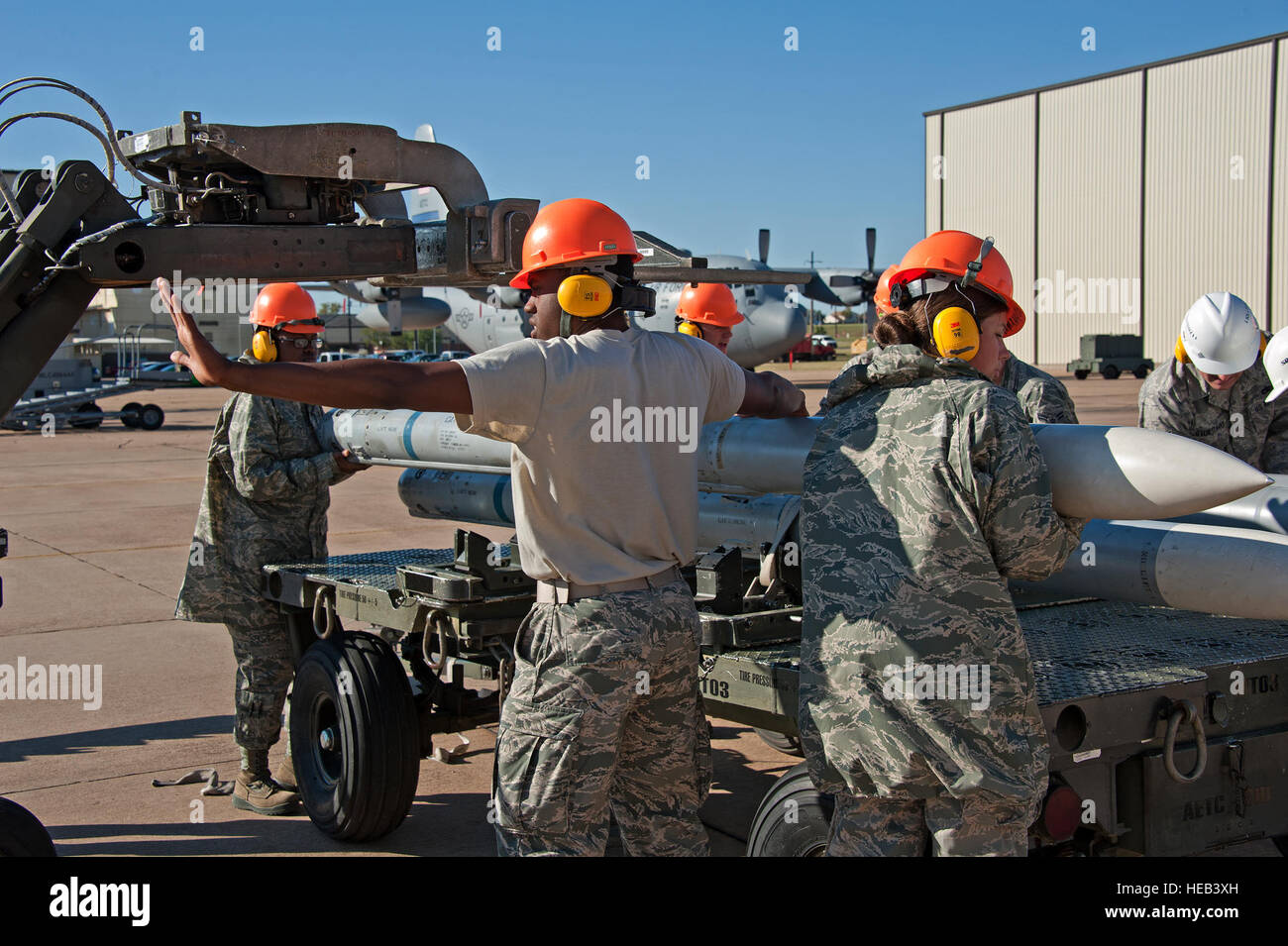 Airmen from the 363rd Training Squadron position an AIM-120 missile on ...