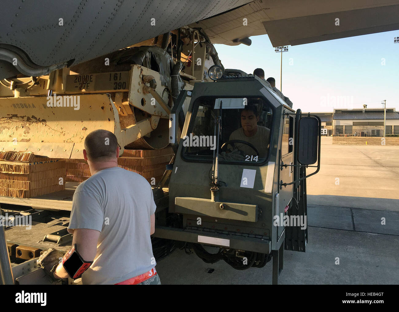 Air Force Tech. Sgt. Joshua Gaines, left, and Airman 1st Class Stacey Svensrud, driver, both assigned to the 3rd Aerial Port Squadron, operate a Halvorsen Loader to load a U.S. Army vehicle onto a C-130H Hercules aircraft from the 145th Airlift Wing, Charlotte, N.C. on Jan. 21, Pope Army Airfield, N.C. This operation was supporting daily Joint Airborne/Air Transportability Training sorties conducted at Pope Field. Stock Photo
