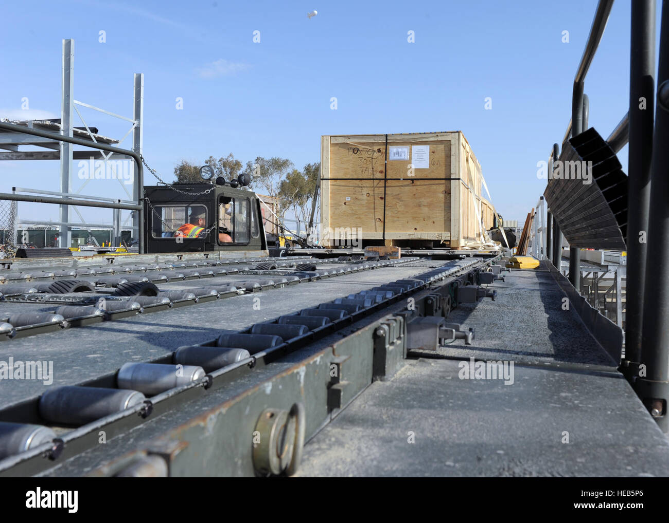 A crate sits on a K loader prior to being transported to an aircraft in
