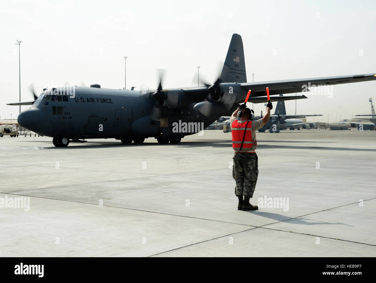 Senior Airman Steven Engels, 379th Expeditionary Aircraft Maintenance Squadron crew chief, marshals a C-130 Hercules on the flight line June 28, 2016, at Al Udeid Air Base, Qatar. Airmen from the 379th EAMXS are responsible for ensuring the aircraft are maintained to exact standards to support Operation Inherent Resolve and Operations Freedom’s Sentinel. Senior Airman Janelle Patiño Stock Photo