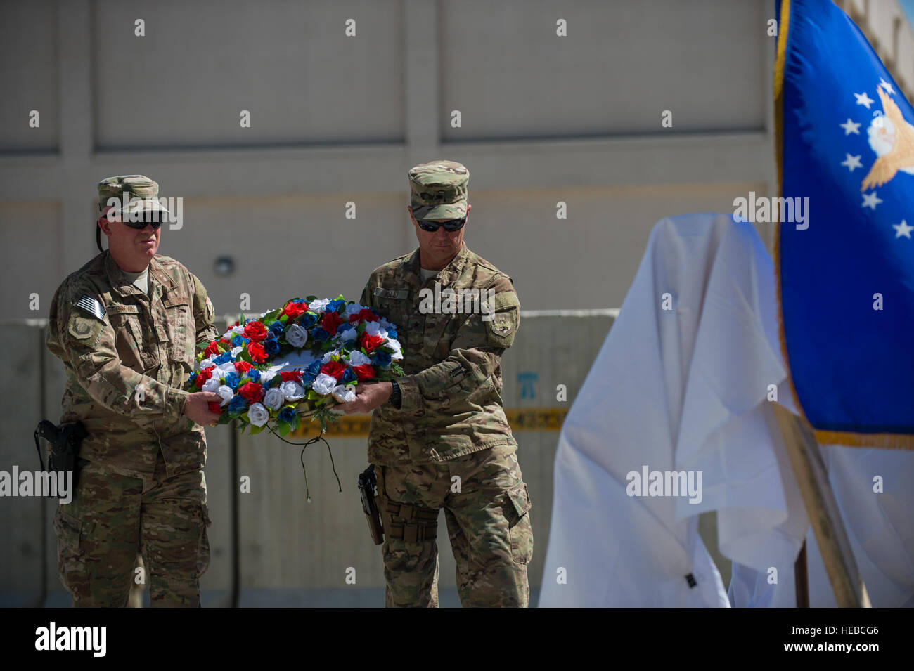 U.S. Air Force Brig. Gen. Mark D. Kelly, right, 455th Air Expeditionary Wing commander, and Chief Master Sgt. Jeffery Brown, 455th AEW command chief, place a wreath in front of the Air Force flag during the U.S. Forces Afghanistan Memorial Day observance ceremony at Bagram Air Field, Afghanistan, May 25, 2015. Memorial Day is dedicated to remembering U.S. men and women who gave their lives while in military service protecting and defending national interests. (U.S. Air Force photo by Tech Sgt. Joseph Swafford/Released) Stock Photo