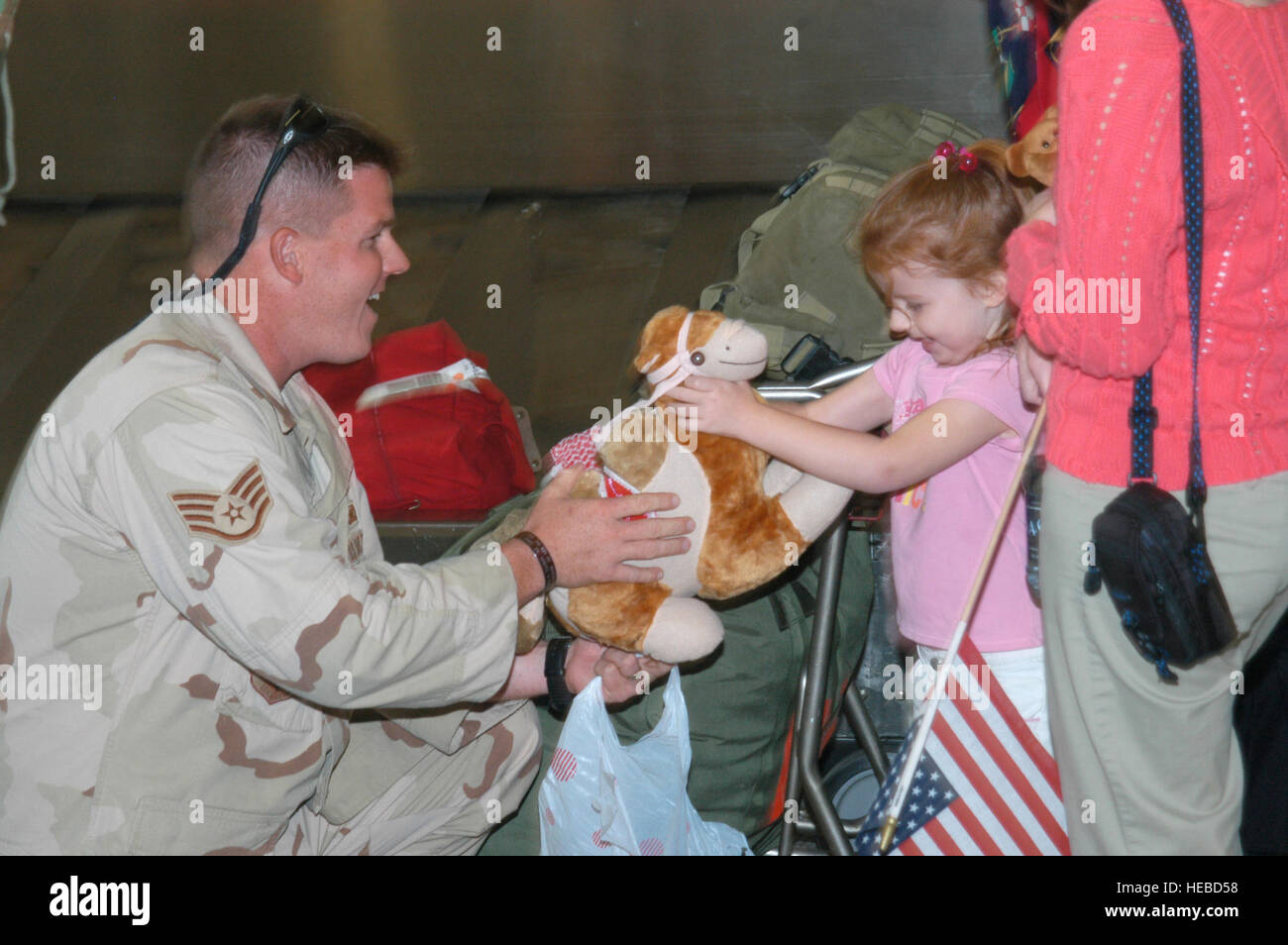 ROBINS AIR FORCE BASE, Georgia -- Staff Sgt Russell Davis presents his daughter with a stuffed camel upon his return from Iraq.  Staff Sgt Davis is a Georgia Air National Guard member from the 116th Security Forces Squadron deployed for 8 months by the 116th Air Control Wing, Robins Air Force Base, Georgia.  (Official Georgia Air National Guard photo by Master Sgt Rick Cowan) Stock Photo