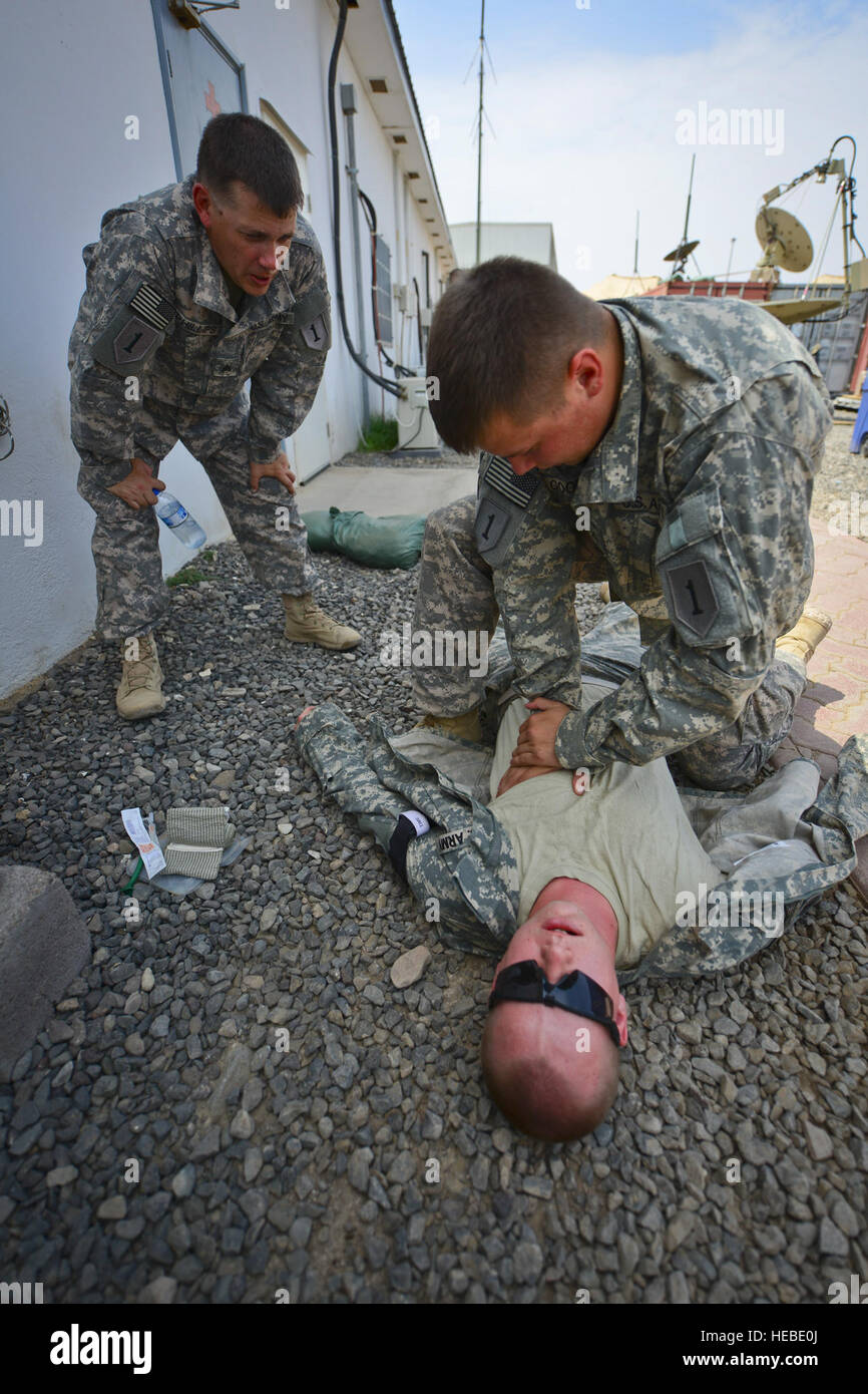 A U.S. Army Pfc. treats a simulated gunshot wound to the chest while a ...