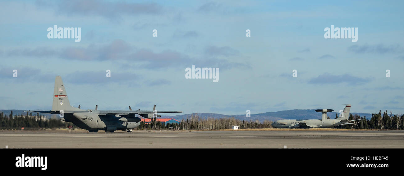 A U.S Air Force C-130 Hercules and an E-3 Sentry AWACS taxi prior to launch during exercise Vigilant Shield 15 at 5 Wing Goose Bay, Newfoundland and Labrador, Oct. 22, 2014. The Vigilant Shield field training exercise is a bi-national NORAD Command exercise which provides realistic training and practice for American and Canadian forces in support of respective national strategy for North America’s defense. NORAD ensures U.S. and Canadian air sovereignty through a network of alert fighters, tankers, airborne early warning aircraft, and ground-based air defense assets cued by interagency and def Stock Photo