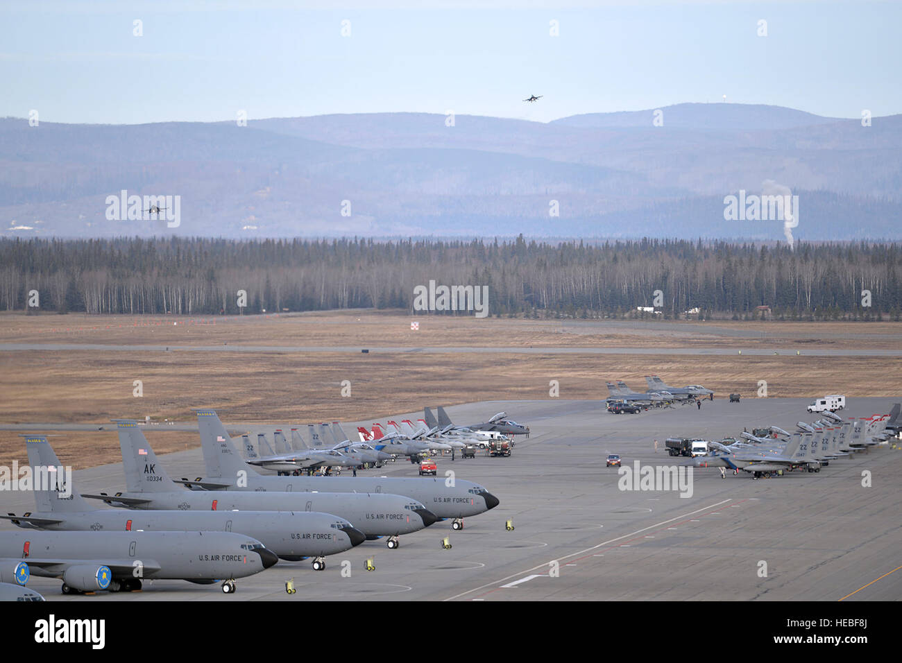 A variety of units aircraft and personnel, including U.S. Marine Corps F/A-18C Hornet aircraft and personnel from Marine Fighter Attack Squadron 232 out of Marine Corps Air Station Miramar, Calif., gather in their ramp space as a pair of U.S. Air Force F-16 Fighting Falcon aircraft assigned to the 36th Fighter Squadron out of Osan Air Base, Republic of Korea, prepare to land at Eielson Air Force Base, Alaska, Oct. 10, 2016, after the first RED FLAG-Alaska (RF-A) 17-1 combat training mission. Pacific Air Forces commander-directed field training exercises like RF-A are vital to maintaining peace Stock Photo