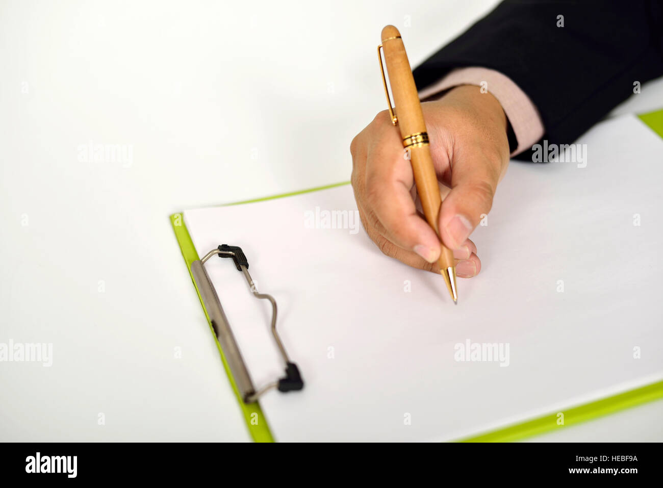 Business man writing on clipboard on the desk Stock Photo - Alamy