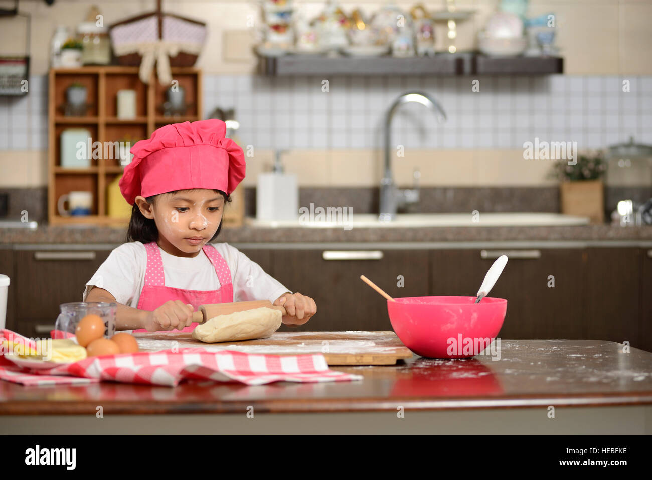 Little asian girl making dough in the kitchen Stock Photo Alamy
