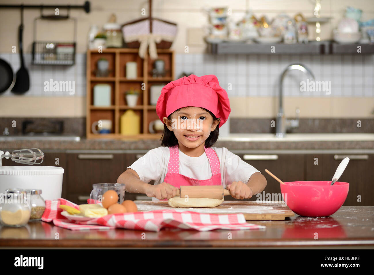 Little asian girl making dough in the kitchen Stock Photo Alamy