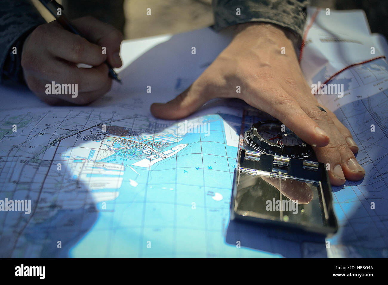 A Member of the Joint Communications Support Element assesses a map for the best communications establishment while on Pine Key Island off the coast of MacDill Air Force Base, Fla., March 4, 2015. One team setup their equipment on the base’s shoreline, another team traveled by boat to a secluded island to test their rapid deployment capabilities, and ability to communicate worldwide. (U.S. Air Force photo by Tech. Sgt. Brandon Shapiro/Released) Stock Photo