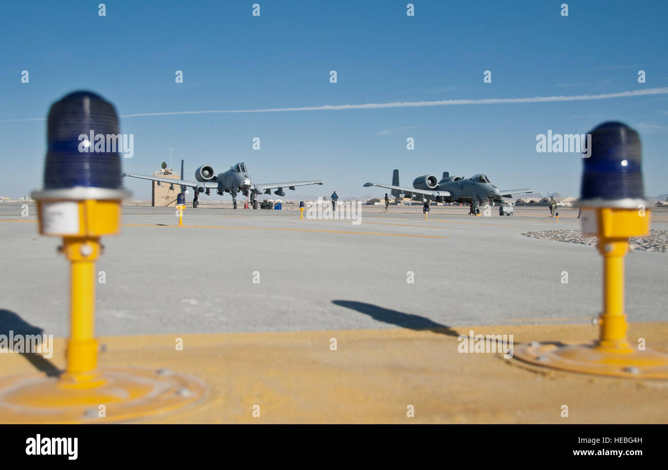 Weapons load crew chiefs perform end-of-runway inspections on two A-10 Thunderbolt IIs at Kandahar Airfield, Afghanistan, Jan. 20, 2012. The A-10 can employ a wide variety of conventional munitions, including general purpose bombs, cluster bomb units and laser-guided bombs. Stock Photo