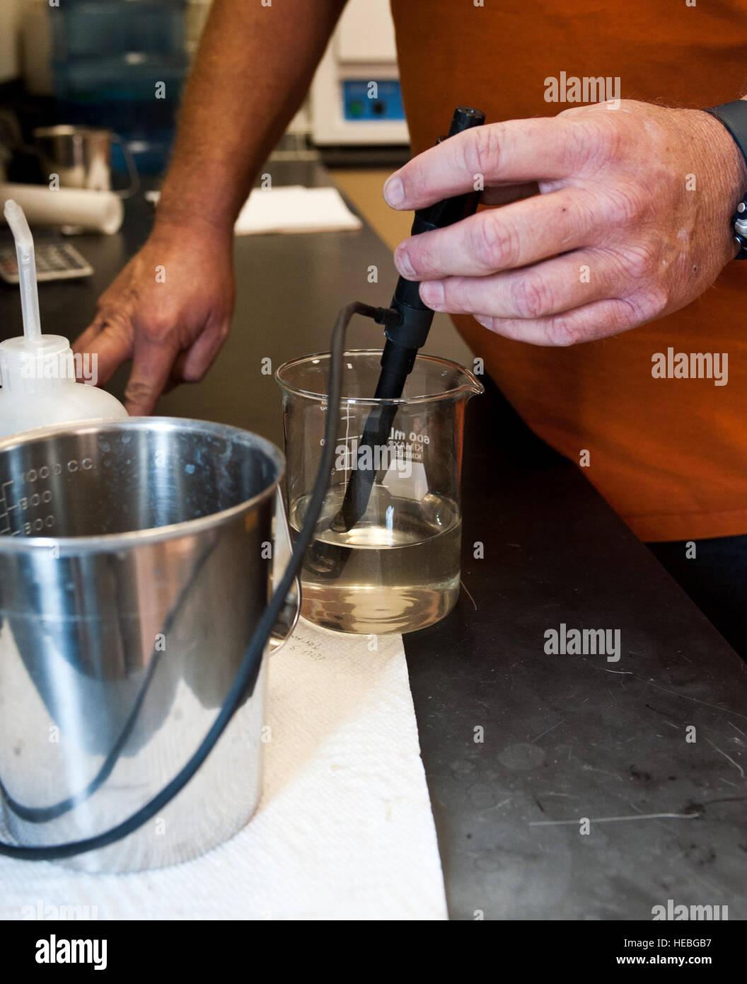 A laboratory technician conducts pH testing on a water sample during ...