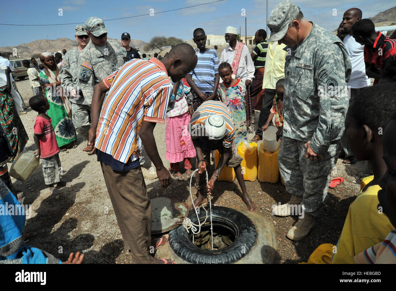 ALI ADDE, Djibouti (Feb. 9, 2012) – Villagers demonstrate how to draw water from a community well they dug by hand to U.S. Army Sergeant Major Richard Erickson, U.S. Army 257th Engineer Team here, February 9. The 257th Engineer Team, in support of Combined Joint Task Force - Horn of Africa, is visiting Ali Adde to conduct analysis of wells drilled by the U.S. military to assess their performance. Site data will help shape future water well-drilling operations. (U.S. Air Force photo by Staff Sergeant Joseph A. Araiza/Released) Stock Photo