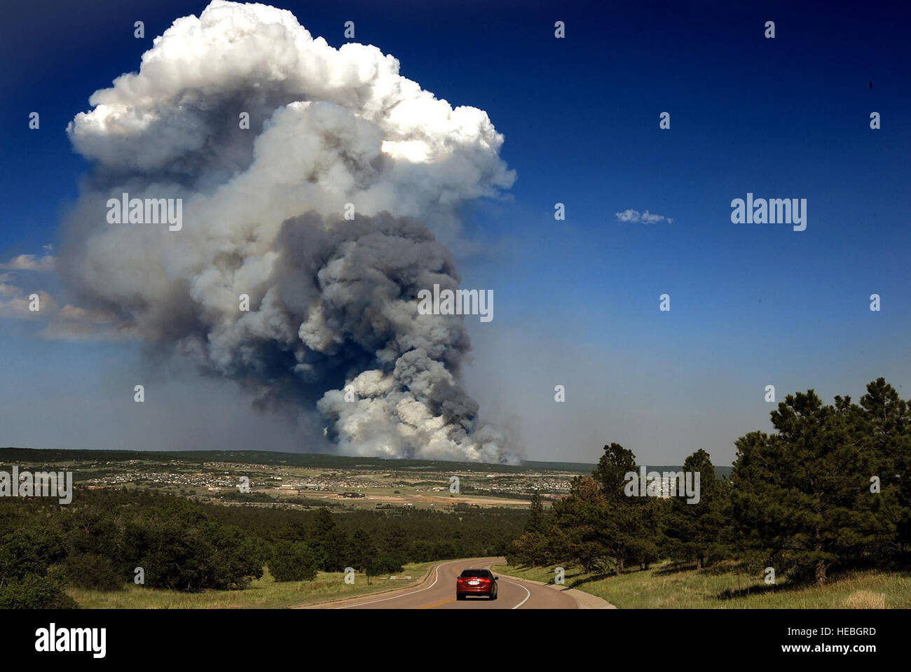 The Black Forest Fire smolders several miles east of the U.S. Air Force Academy in this shot taken near the Cadet Chapel June 11, 2013, in Colorado Springs, Colo. The fire burned between 7,500 and 8,000 acres the first day approximately 100 homes. More than 5,000 people were evacuated from an additional 1,700 homes. (U.S. Air Force photo/Carol Lawrence) Stock Photo