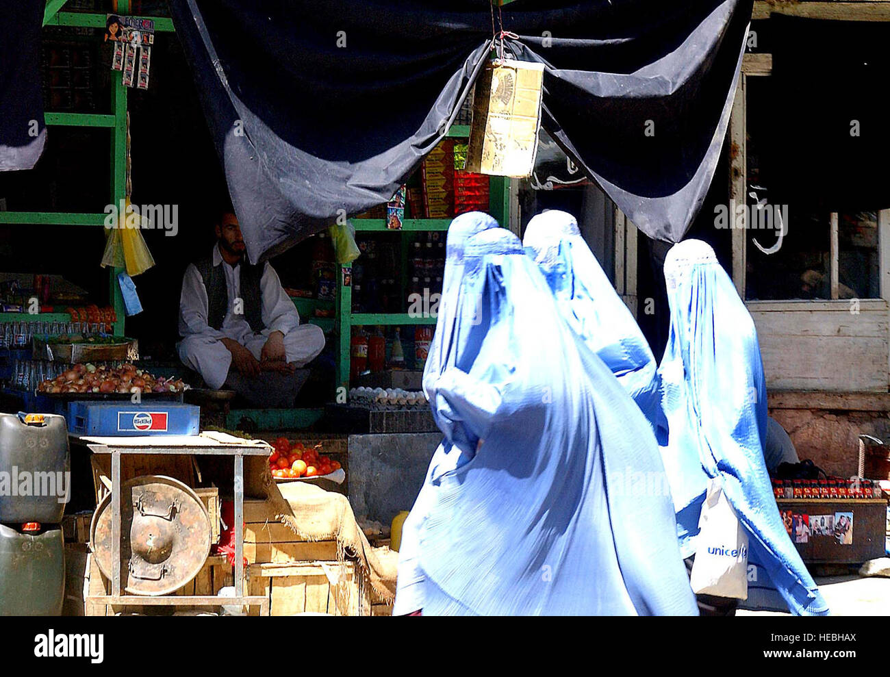 Even though the Taliban have been removed from power in Afghanistan, many of the Muslim women still adhere to the strict interpretation of Muslim law that the Taliban mandated. These women shopping at a market in the Parwan Province of Afghanistan, Sept. 8, 2002, still wear the traditional Burka while in public. (U.S. Air Force photo by Staff Sgt. Derrick C. Goode) (Released) Stock Photo