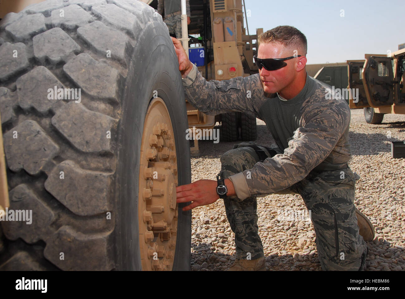 Senior Airman Ryne Ritchie, 532nd Expeditionary Security Forces Squadron truck commander, inspects the lug nuts on an MRAP July 25, at Joint Base Balad, Iraq. Preparation inspections are done before each patrol to ensure equipment, vehicles, and weapons are working properly. Ritchie is deployed from Travis Air Force Base, Calif., he is a native of Chino, Calif. Stock Photo