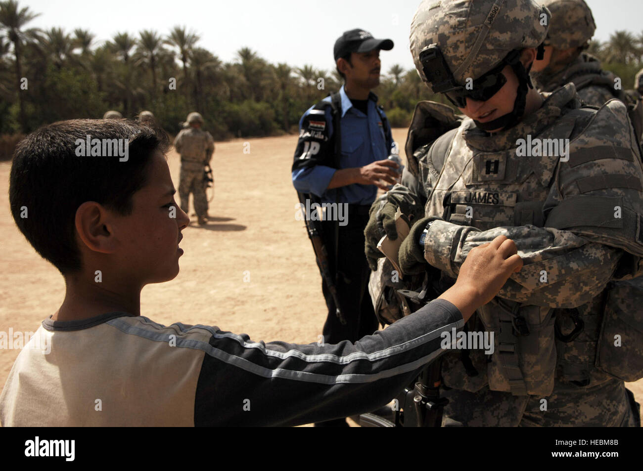 U.S. Army Capt. Norma James, commander of the 411th Military Police Company, 716th Military Police Battalion, 101st Airborne Division, interacts with a local boy in Abayachi, Iraq, March 30, 2008. (U.S. Air Force photo by Tech. Sgt. William Greer) (Released) Stock Photo