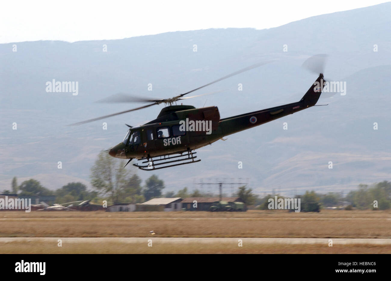 This UH-1N Iroquois or Huey helicopter from Slovenia, flies over Krumovo Air Base (AB) in Bulgaria (BG), securing the airfield as part of exercise Cooperative Key 2003. Exercise Cooperative Key is designed to promote procedural dialogue between North Atlantic Treaty Organization (NATO) and partner nations. Stock Photo