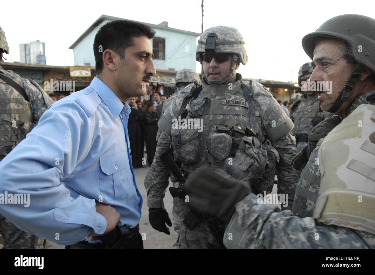 U.S. Army Lt. Col. Drew Meyerowich (center), battalion commander, 2nd Battalion, 27th Infantry Regiment, 3rd Brigade Combat Team, 25th Infantry Division, discusses security issues with the Iraqi police through an interpreter 'Cowboy' (right). U.S. Army Soldiers travel to Alzab on a humanitarian assistance re-supply of 5,000 gallons of diesel fuel, 5,000 gallons of kerosene and 525 canisters of propane due to the bridge spanning the Little Zab River being blown by an insurgent's improvised explosive device, Province of Kirkuk, Iraq, March 25. U.S. Soldiers are with Headquarters Company, 2nd Bat Stock Photo