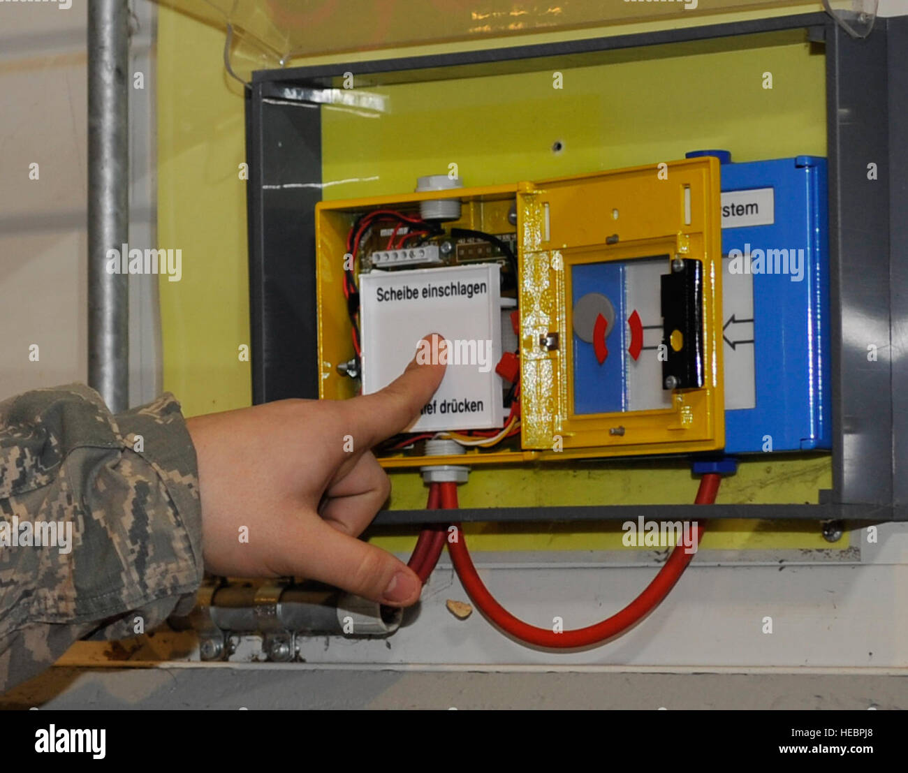 Senior Airman Nikko Miranda, 721st Aircraft Maintenance Squadron facility manager, presses the button to release water during a biennial fire suppression system test, Feb. 19, 2015 at Ramstein Air Base, Germany. Approximately 4,500 gallons of water per minute was emitted from a 40,000 gallon tank. The hangar was closed for two days to conduct the test. (U.S. Air Force photo/Airman 1st Class Larissa Greatwood) Stock Photo