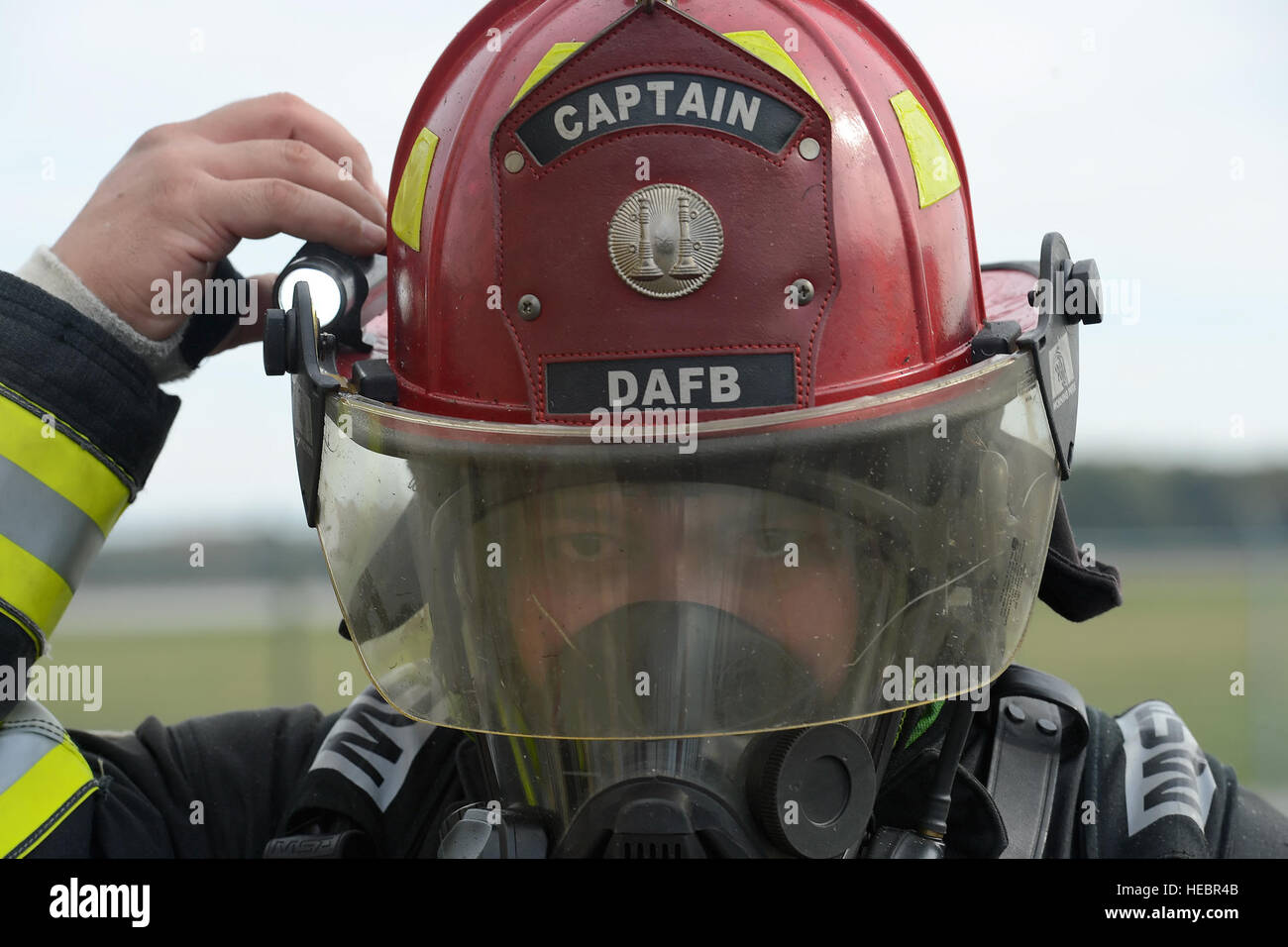 Tech. Sgt. Ryan Atoigue adjusts a light attached to his helmet while participating in structural fire training Oct. 20, 2014, at Dover Air Force Base, Del. Atoigue's helmet indicates that he is a firecrew captain with the 436th Civil Engineer Squadron. (U.S. Air Force photo/Greg L. Davis) Stock Photo
