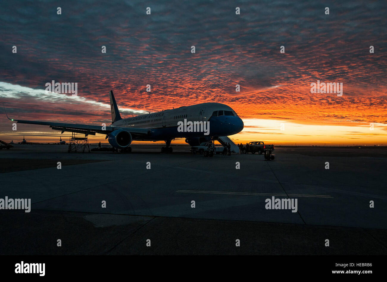 The sun rises over a 1st Airlift Squadron C-32A at Travis Air Force Base, Calif., March 13, 2015. The 89th Airlift Wing flies a variety of aircraft and in addition to the Boeing C-32A, the 1st AS flies Boeing C-40Bs, the 99th Airlift Squadron flies Gulfstream C-20B, C-37A and C-37Bs, and the Presidential Airlift Group flies Boeing VC-25s. Together the units, in conjunction with the remainder of the 89th Operations Group, 89th Maintenance Group, 89th Airlift Support Group and 89th AW staff align efforts to enable national interests through global transportation for America’s senior leaders, ens Stock Photo