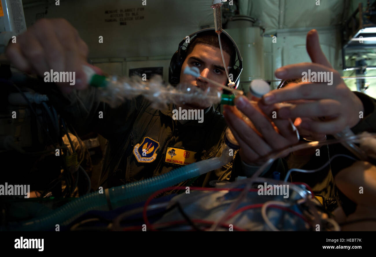 Senior Airman Carlos Sanchez-Perez, Critical Care Air Transport Team respiratory technician, stabilizes a simulated patient during a training flight with the 86th Aeromedical Evacuation Squadron March 26, 2015, above Ramstein Air Base, Germany. The exercise scenario was performed on board a 37th Airlift Squadron C-130J Super Hercules to help perfect the potentially new TCCET-E capability, which gives the 86th AES and flight surgeons the ability to do quick, critical surgeries as fast as possible while in transit to a hospital. (U.S. Air Force photo/Staff Sgt. Sara Keller) Stock Photo
