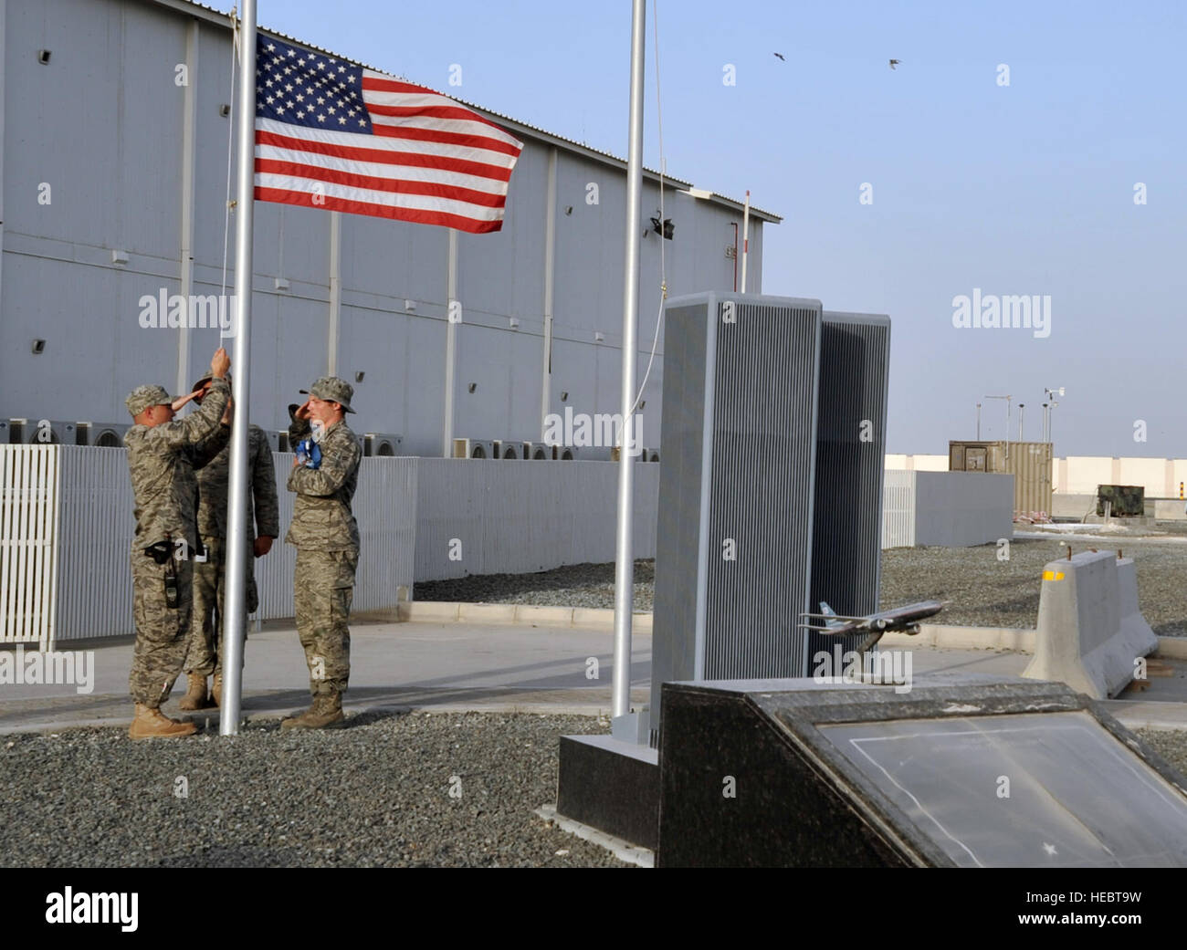 Firefighters from the 380th Expeditionary Civil Engineer Squadron Fire Department prepare to lower the American flag at the 380th Air Expeditionary Wing's 9-11 memorial at the end of the duty day at a non-disclosed base in Southwest Asia on May 29, 2010.  The memorial is a tribute to the men and women who died in the terrorist attacks in the United States on Sept. 11, 2001. The wing is home to the KC-10 Extender, U-2 Dragon Lady, E-3 Sentry and RQ-4 Global Hawk aircraft. The 380th AEW is comprised of four groups and 12 squadrons and the wing's deployed mission includes air refueling, air battl Stock Photo