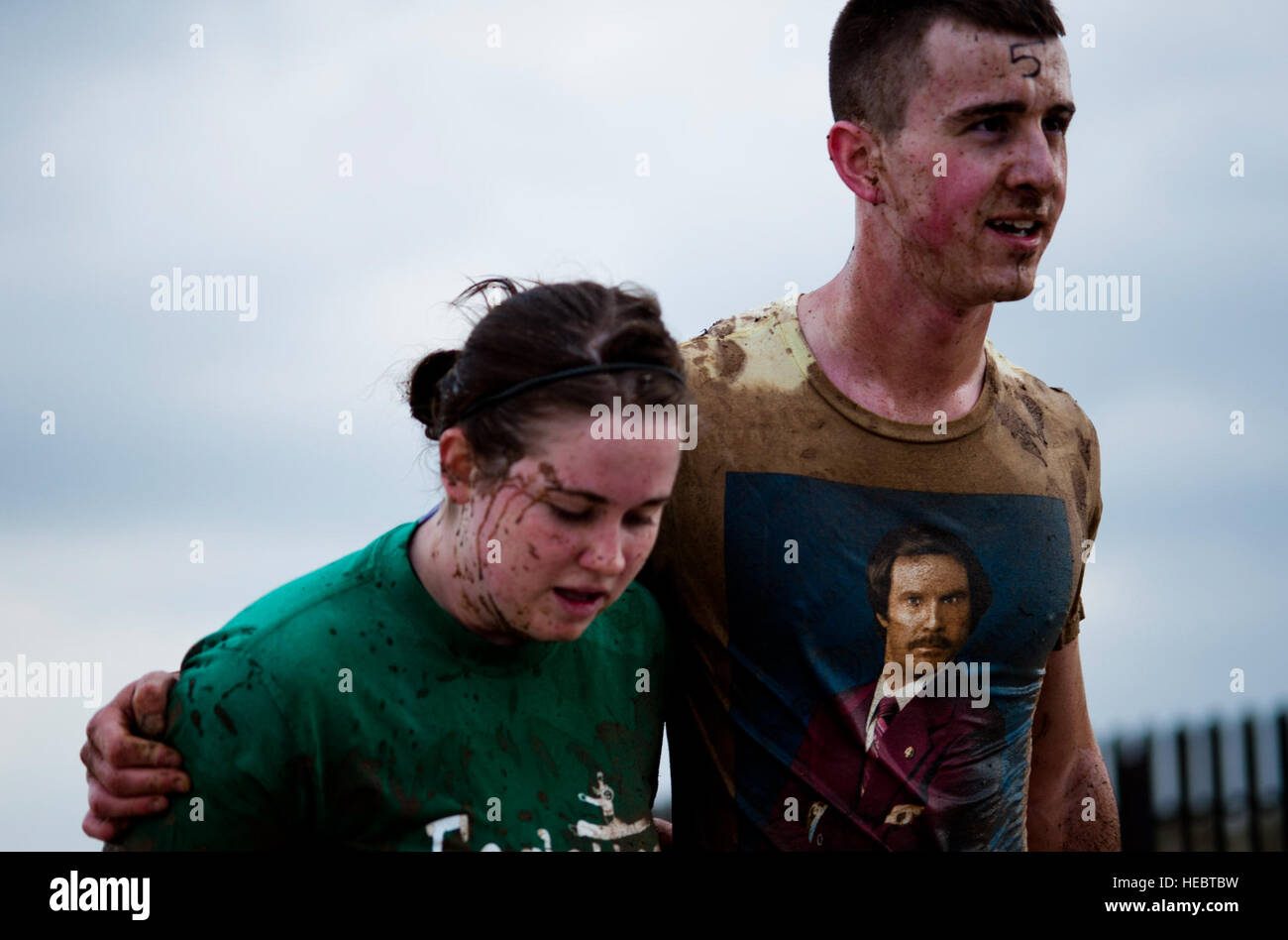 Participants in the Women's History Month Ultimate Dirty Dash help each other to the next obstacle March 31, 2012, at Incirlik Air Base, Turkey. The 27-obstacle event began and ended at Arkadas Park. The course included a wooden pyramid, an ice water mud pit, a tire flip and piggy-back style carry. Stock Photo